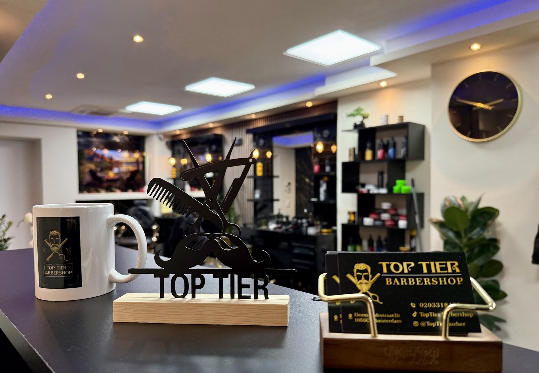 De balie met een Top Tier mok, het gouden logo en visitekaartjes
